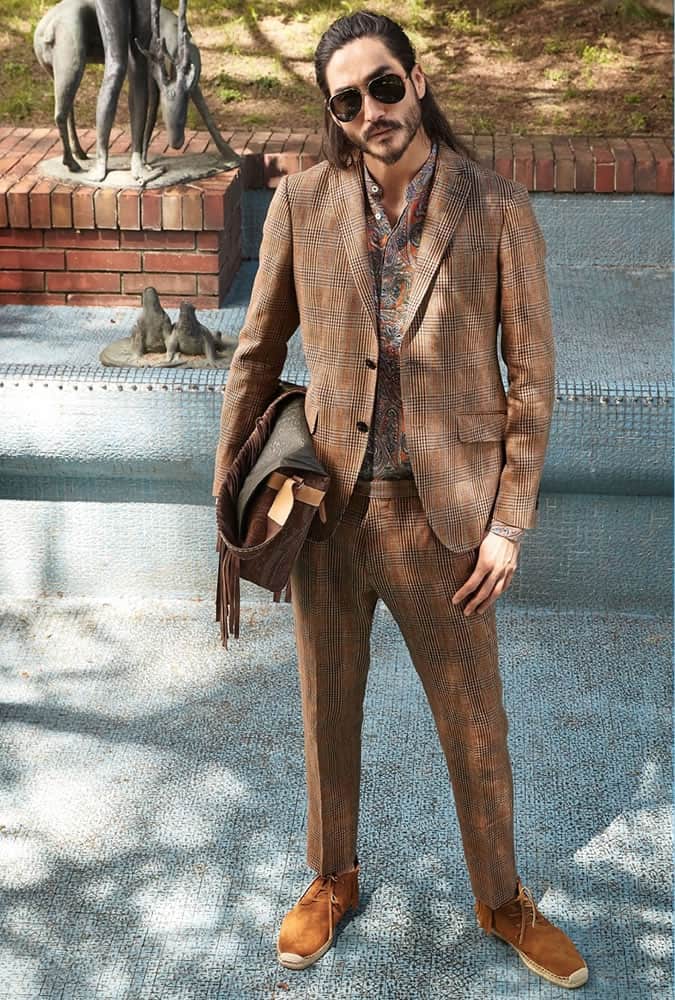 Người đàn ông mặc một bộ quần áo kiểm tra với một chiếc áo sơ mi paisley