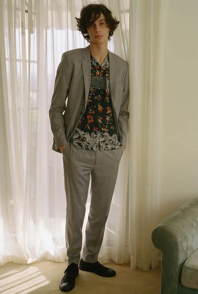 Người đàn ông mặc một bộ quần áo với một chiếc áo sơ mi có hoa văn