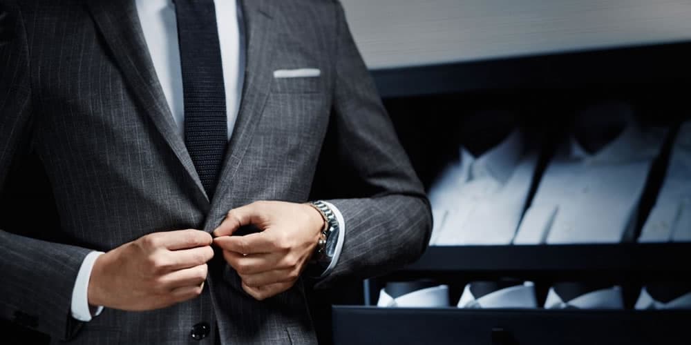Người đàn ông mặc bộ đồ màu xám với cà vạt màu xanh hải quân